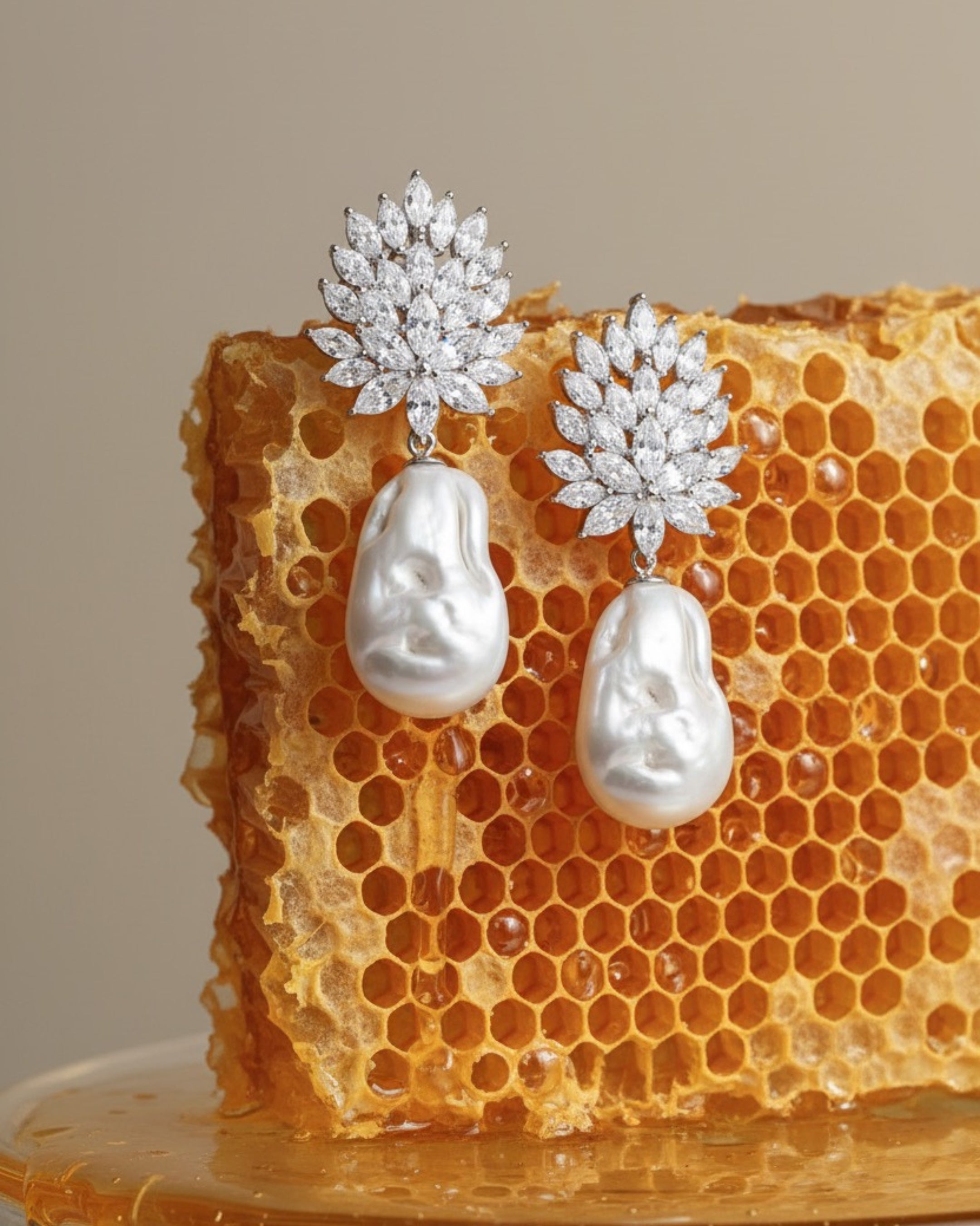 Vista frontal de los pendientes Éclat con perla barroca y piedras blancas en talla marquesa.