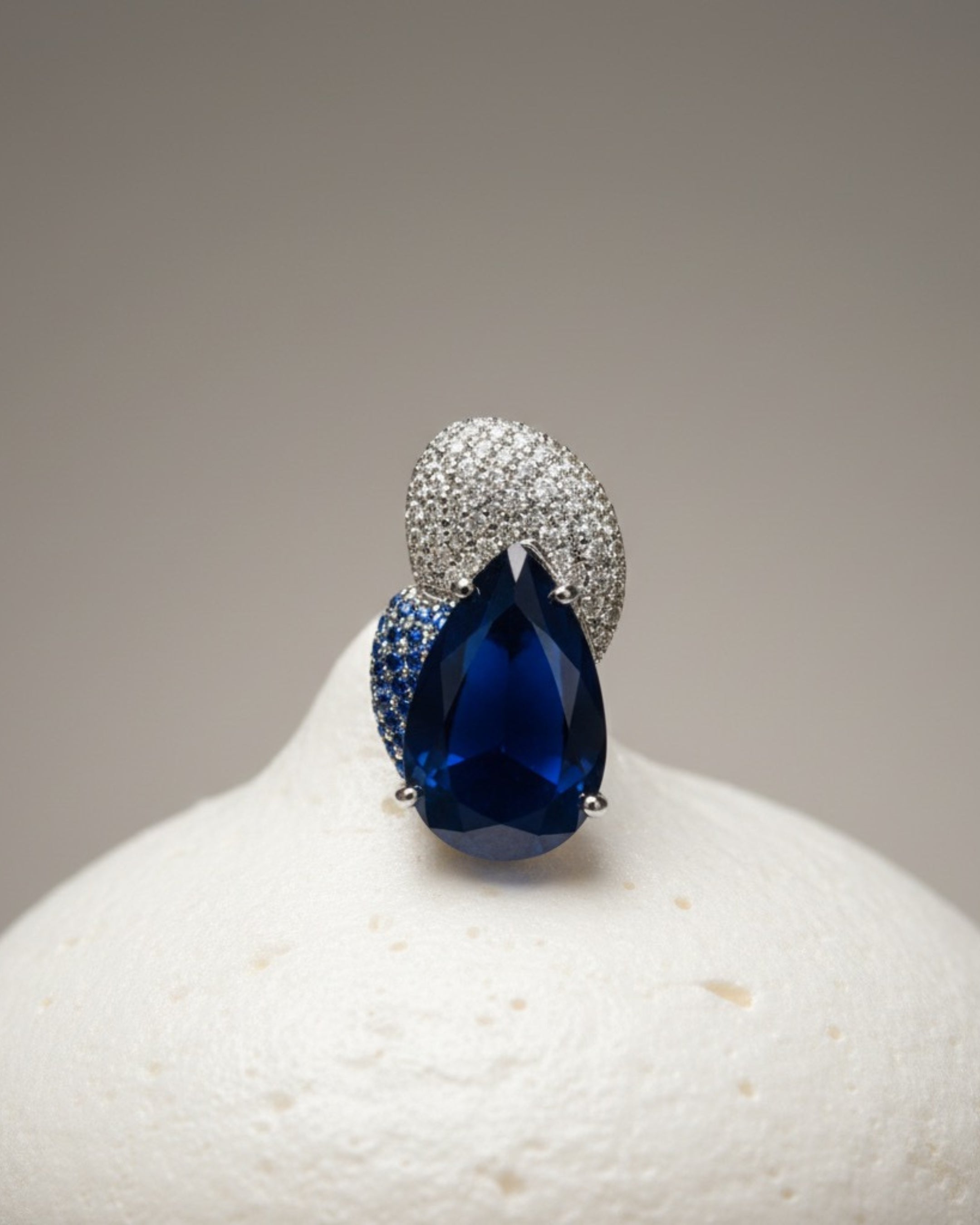 Pendientes elegantes con piedra azul intensa en talla gota y diseño delicado lleno de brillo.