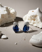 Pendientes Epoc con piedra azul estilo zafiro y pequeños detalles brillantes que realzan la pieza.