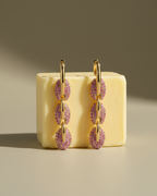 Pendientes elegantes de eslabones con piedras rosas y acabado en oro amarillo.