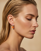 Pendientes esmaltados femeninos con detalles coral y acabado en oro amarillo.