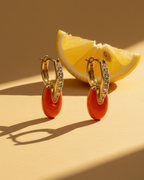 Pendientes con esmalte coral y acabado en oro amarillo llenos de luz y personalidad.