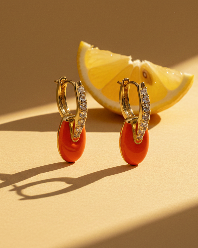 Pendientes con esmalte coral y acabado en oro amarillo llenos de luz y personalidad.