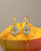 Pendientes colgantes para mujer con piedra azul brillante y acabado en oro amarillo.