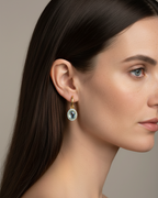 Pendientes luminosos con piedra azul y acabado en oro amarillo elegante.