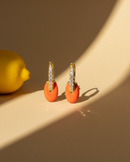 Pendientes de joyería coral con esmalte brillante y diseño refinado.