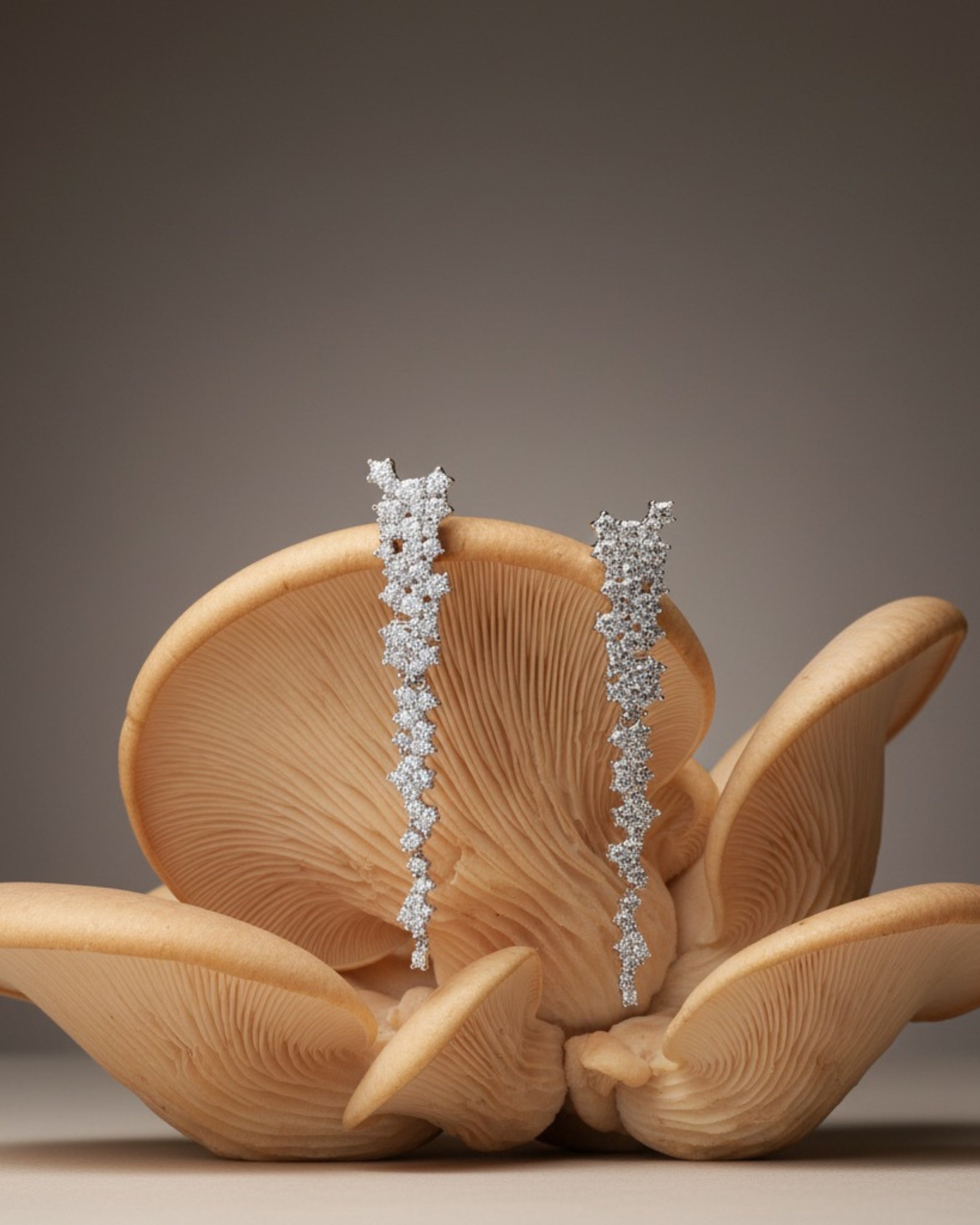 Pendientes Líridas decorados con piedras en talla circular que reflejan la luz desde todos los ángulos.