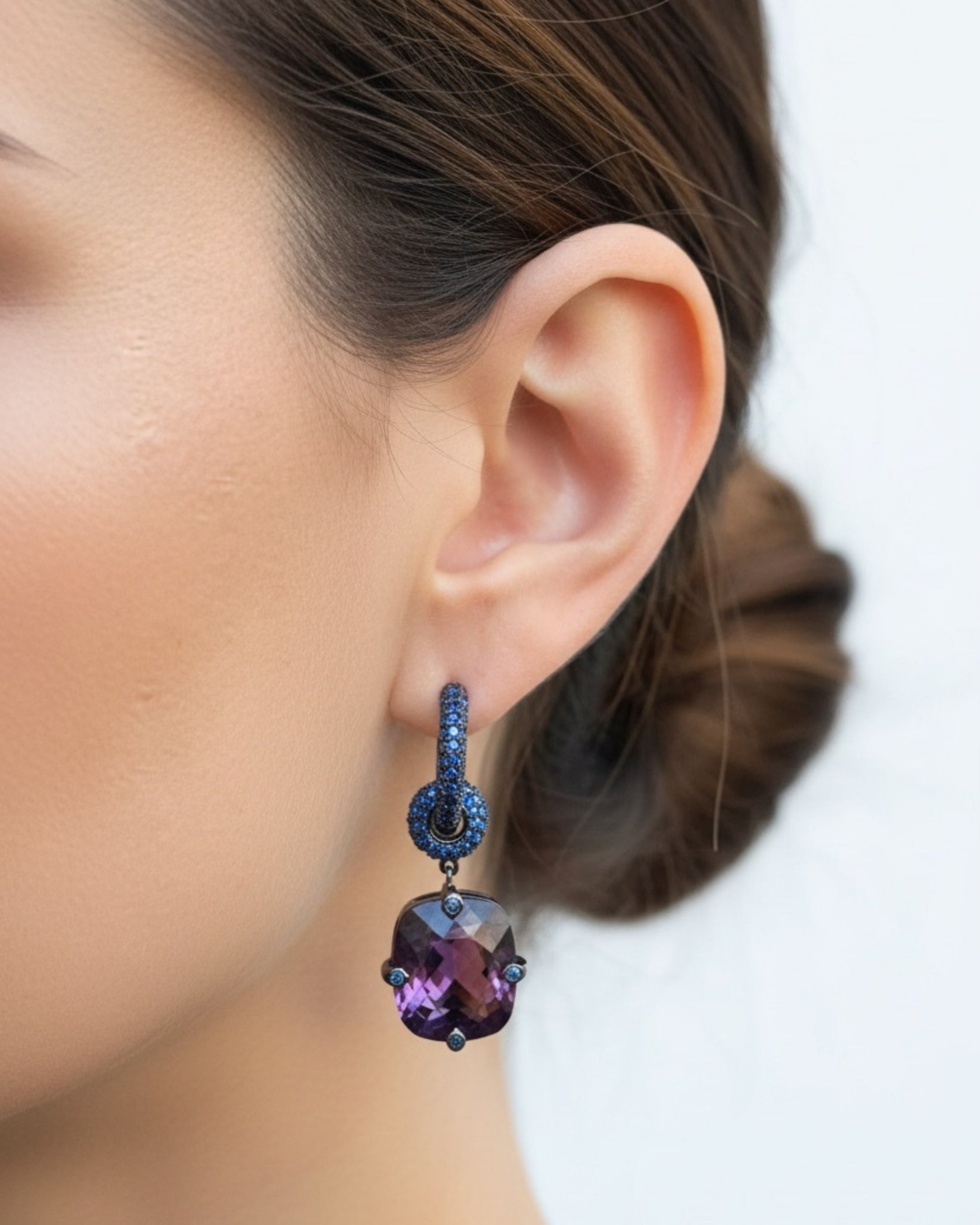 Pendientes Lyss con brillo intenso en rodio negro, decorados con piedras azules y violeta. Diseño sofisticado que aporta profundidad y elegancia.