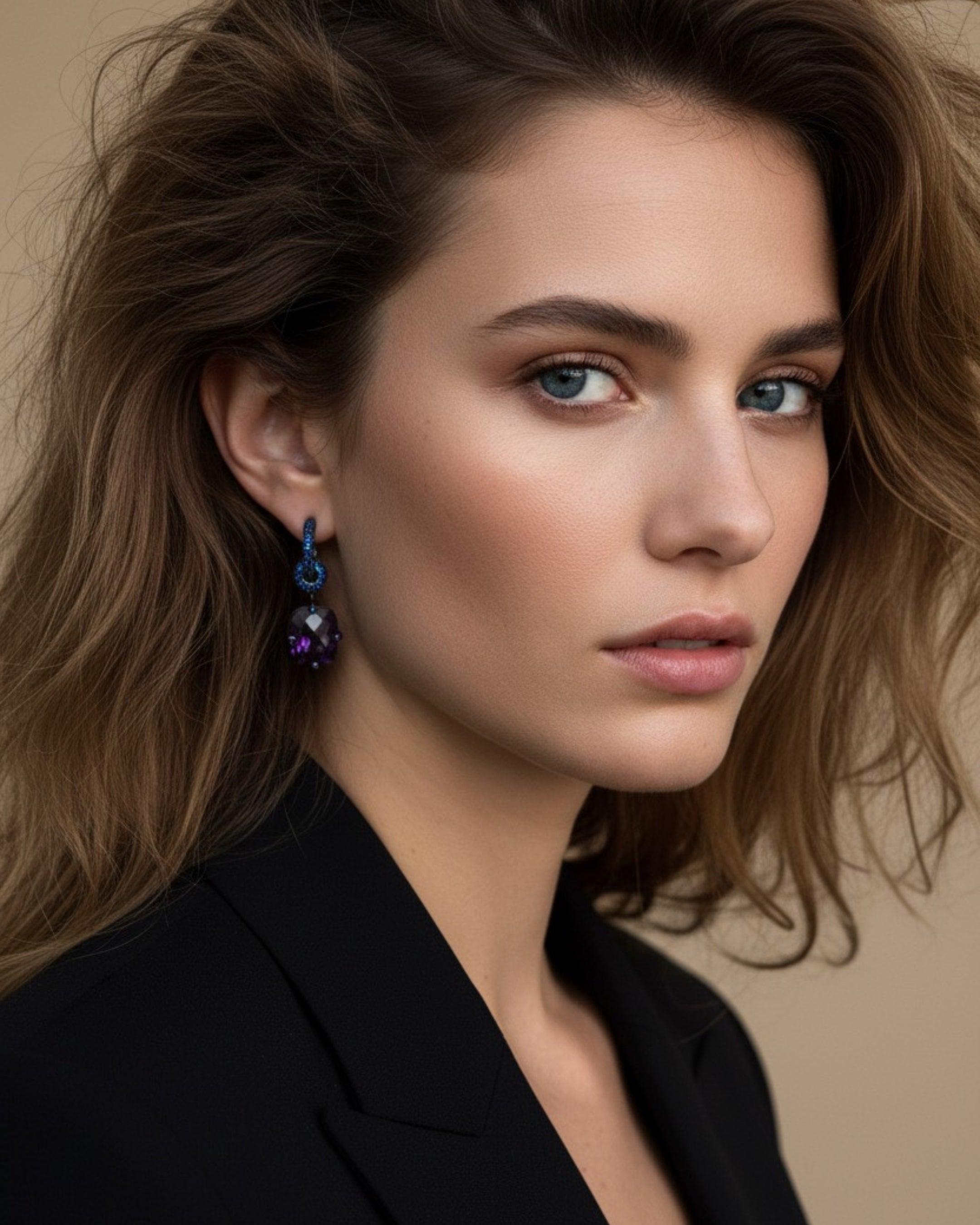 Detalle de los pendientes Lyss con piedra principal violeta en talla radiant Ceilán sujeta por cuatro garras con pequeñas piedras azules.