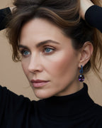 Pendientes Lyss de Sibela con piedras grandes en tonos azul zafiro y violeta. Una pieza llamativa con acabado en rodio negro y diseño elegante.