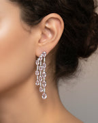Pendientes Medusa con diseño elegante en tonos rosa y pequeñas piedras brillantes que reflejan la luz.