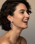 Detalle de los pendientes Medusa con piedras en talla oval rosa claro y brillo delicado.