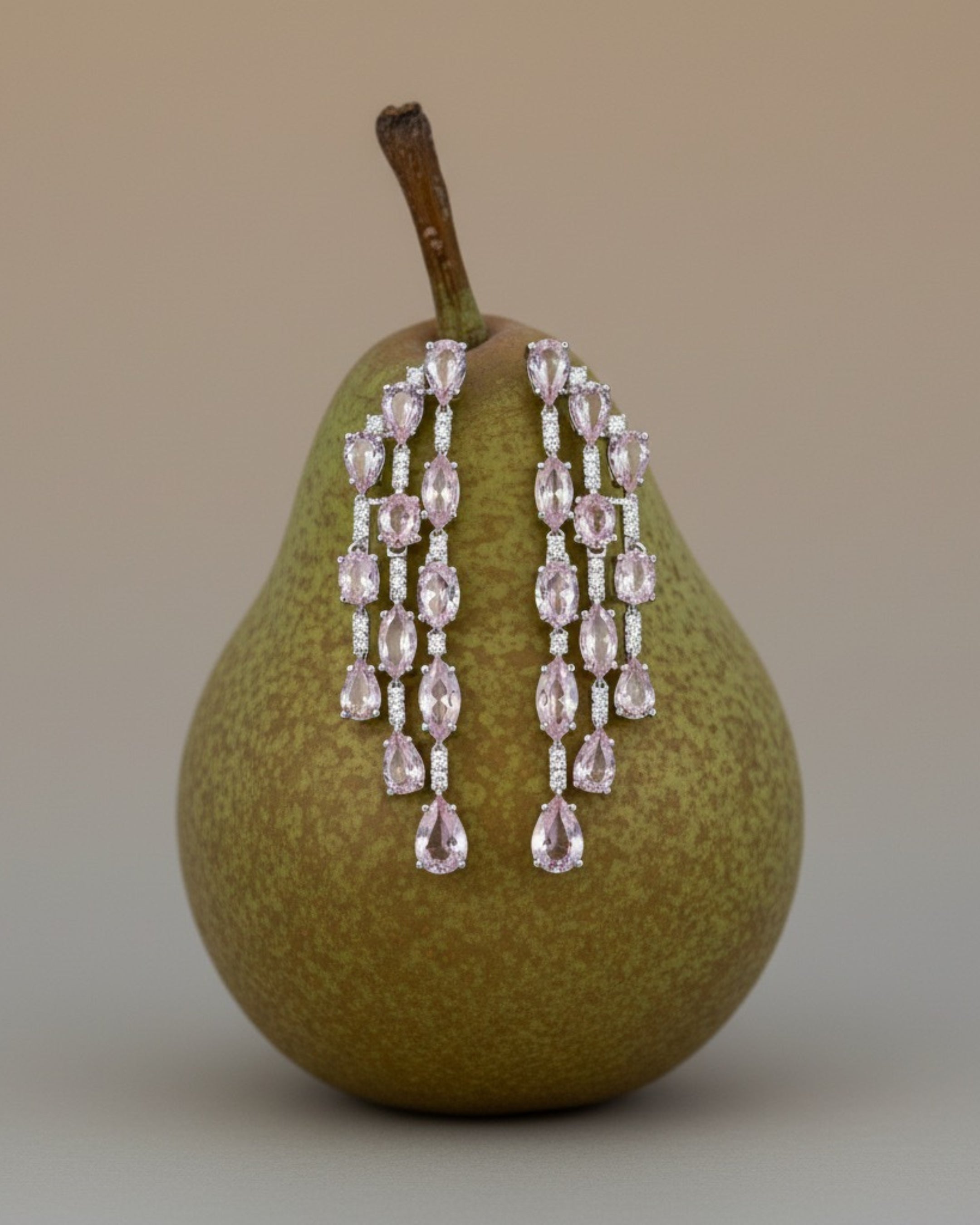 Pendientes Medusa con piedras en tono rosa claro y detalles brillantes que aportan elegancia y luminosidad.