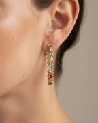 Pendientes Neppi de Sibela Studio en plata de ley 925 con baño en oro amarillo de 18k, diseño tipo lluvia con piedras en talla circular de 2 mm y 3 mm en múltiples colores.