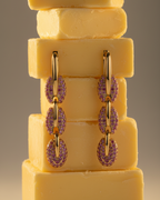 Pendientes con piedras rosas en talla circular y acabado en oro amarillo, sofisticados y luminosos.