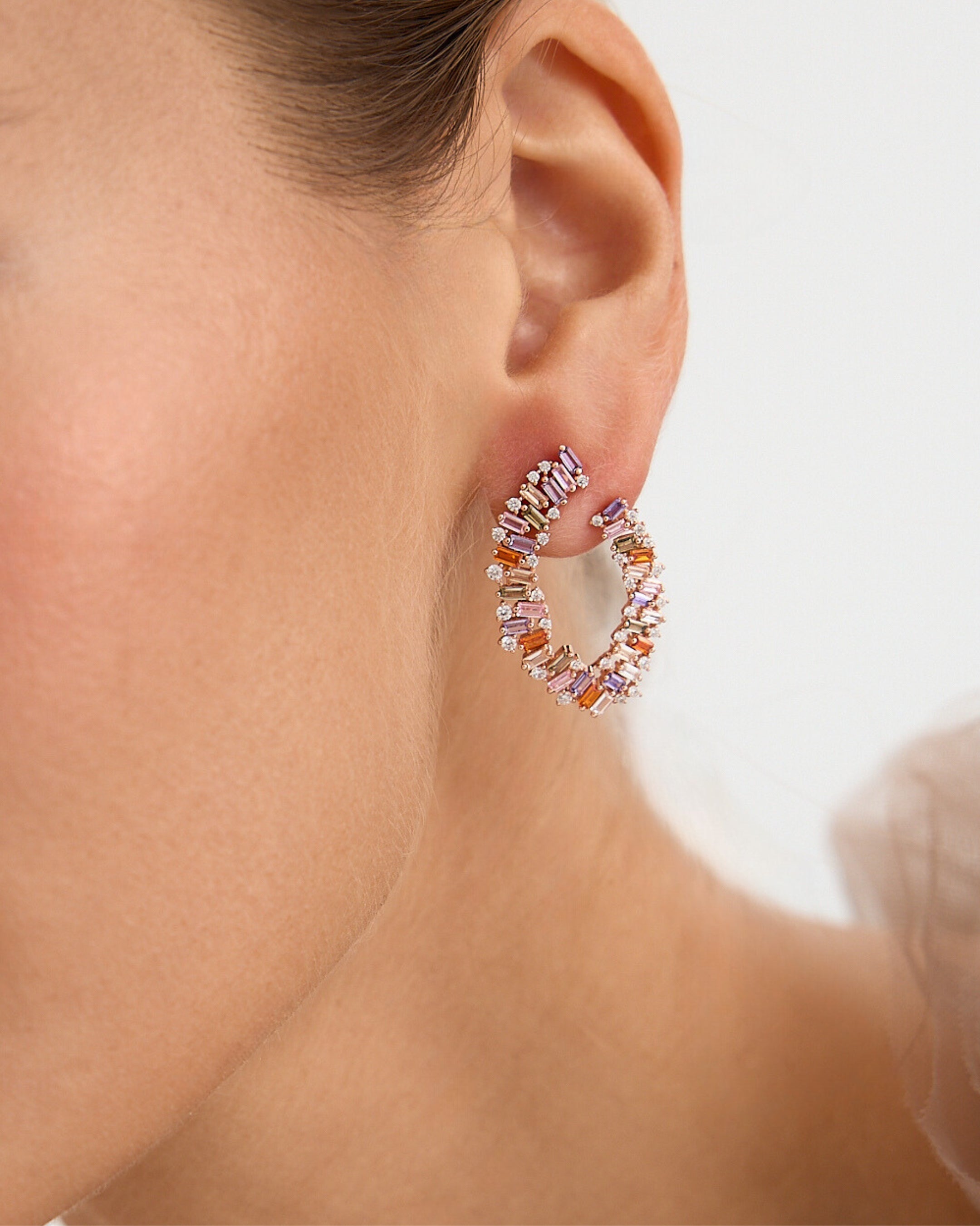 Pendientes en oro rosa con piedras de colores cálidos y diseño elegante y luminoso.