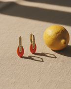 Pendientes oro y coral con circonitas brillantes y estilo femenino.