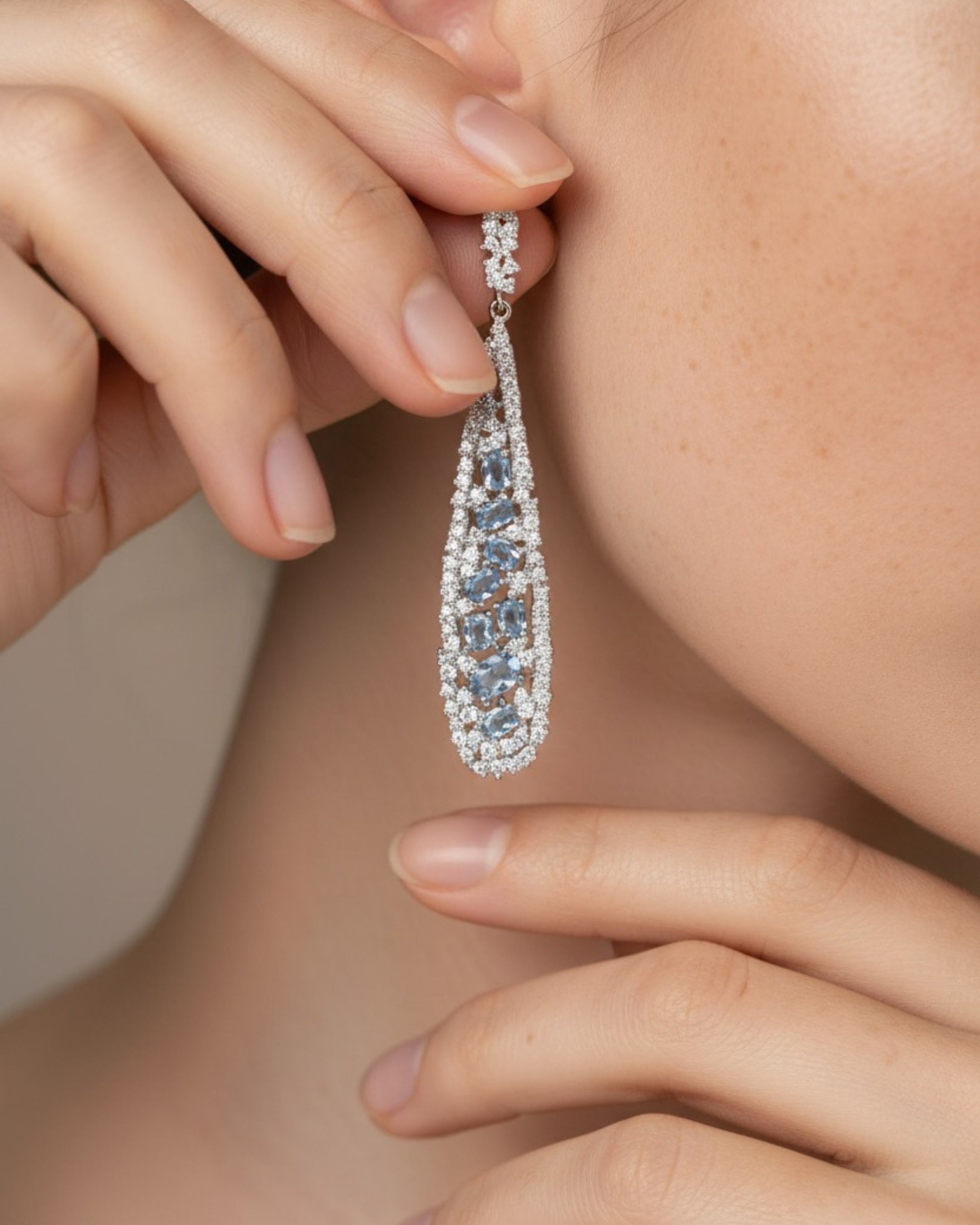 Pendientes con aguamarina en talla oval y circonitas blancas, elaborados en base de alta calidad Sibela con chapado en rodio. Una joya delicada y atemporal.