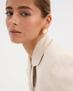 Los pendientes Pearl, inspirados en los elegantes collares de perlas de la era del jazz, combinan lujo y modernidad. Fabricados en plata de ley 925 con un baño de oro amarillo de 18 quilates, estos pendientes destacan por su delicada perla de nácar en talla gota como piedra principal. Con una longitud de 30 mm y cierre de tuerca, son perfectos para quienes buscan una pieza sofisticada y atemporal, ideal para destacar en cualquier evento.