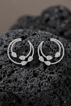 Detalle de los pendientes Zenit con piedras blancas de diferentes tallas y acabado en rodio.