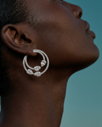 Pendientes Zenit con silueta de aro y diseño decorativo de piedras blancas brillantes.