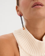 Pendientes Fuso en plata de ley 925 con baño de rodio negro y oro amarillo de 18 kts. Engastados con piedras de tonos rosa, violeta y naranja, cada eslabón está trabajado a mano, combinando arte y elegancia en una pieza sofisticada.