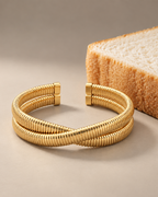 Pulsera abierta VITA de Sibela Studio con acabado dorado y forma estructurada.