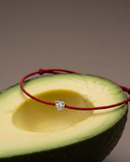 Pulsera minimalista roja con acabado en oro amarillo y diseño delicado.