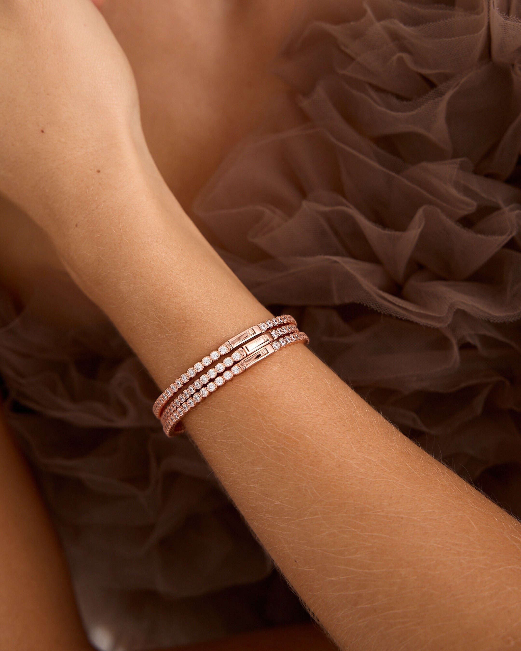 Pulsera brillante oro rosa con circonitas blancas y acabado refinado.
