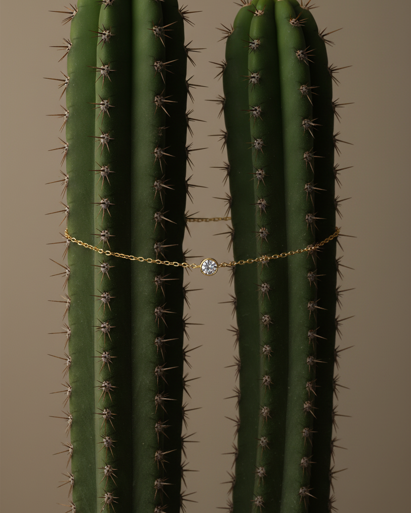Pulsera de cadena fina con circonita blanca central, acabado en oro amarillo de 18 kt y estilo delicado.