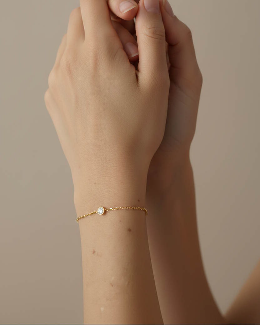 Pulsera elegante con circonita blanca central y acabado en oro amarillo de 18 kt.