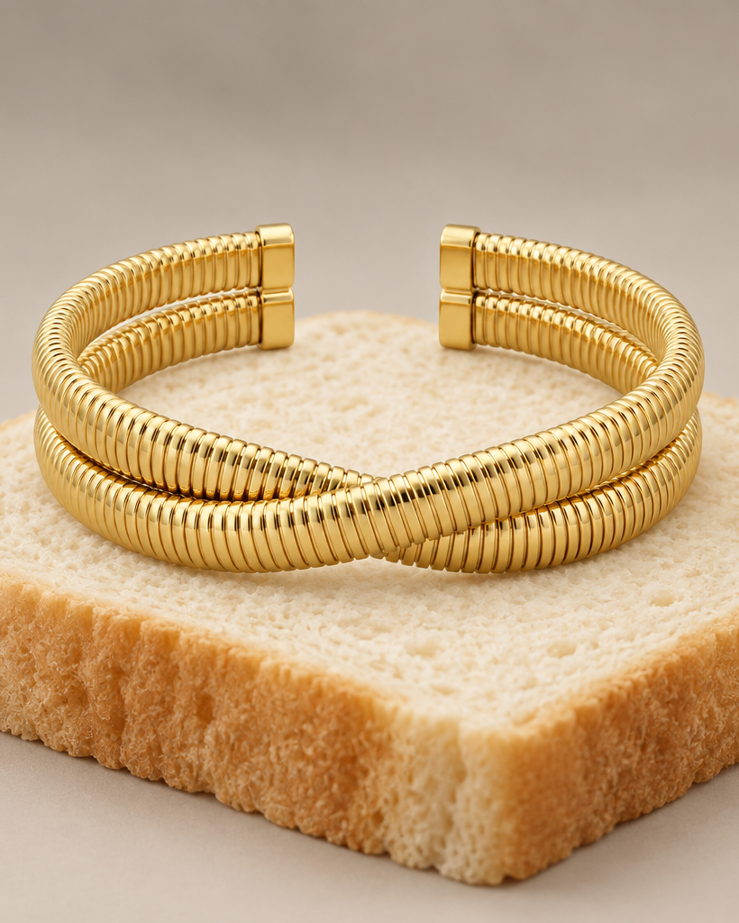 Pulsera dorada rígida VITA con diseño abierto y presencia elegante sobre la muñeca.