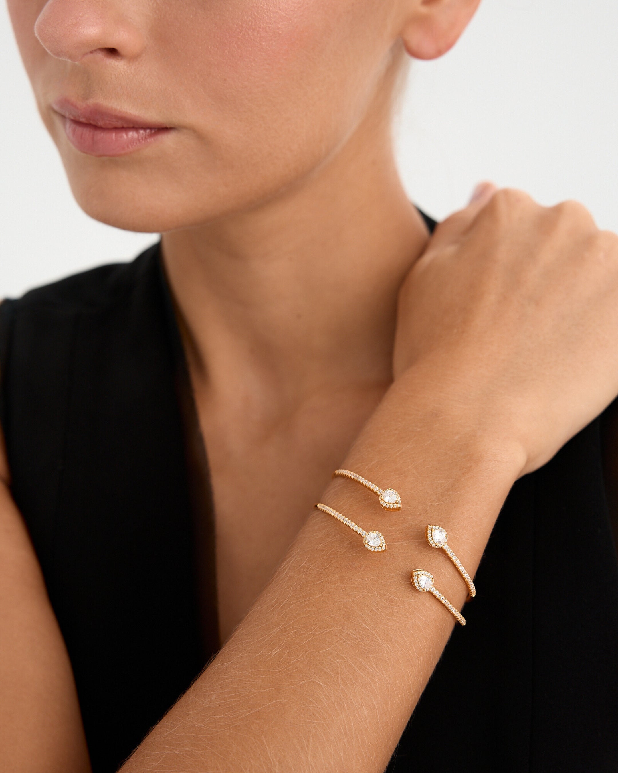 Pulsera Gala en plata de ley 925 con baño de oro amarillo de 18kts, decorada con circonitas blancas y piedras en talla pera de 2 mm. Inspirada en las galas de los años 20, con diámetro de 17 mm y cierre ajustable