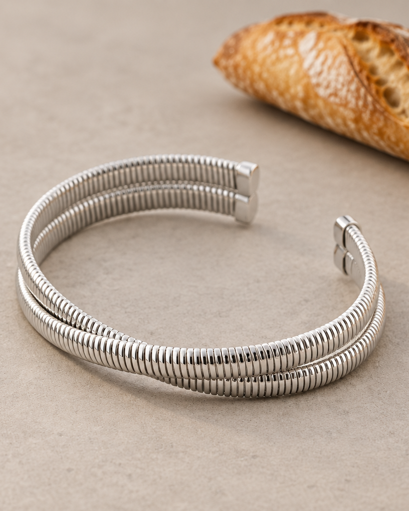 Pulsera LUCE blanca de silueta estructurada con diseño abierto y extremos planos.