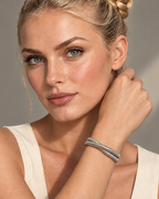 Pulsera rígida LUCE abierta con acabado blanco y silueta limpia y estructurada.