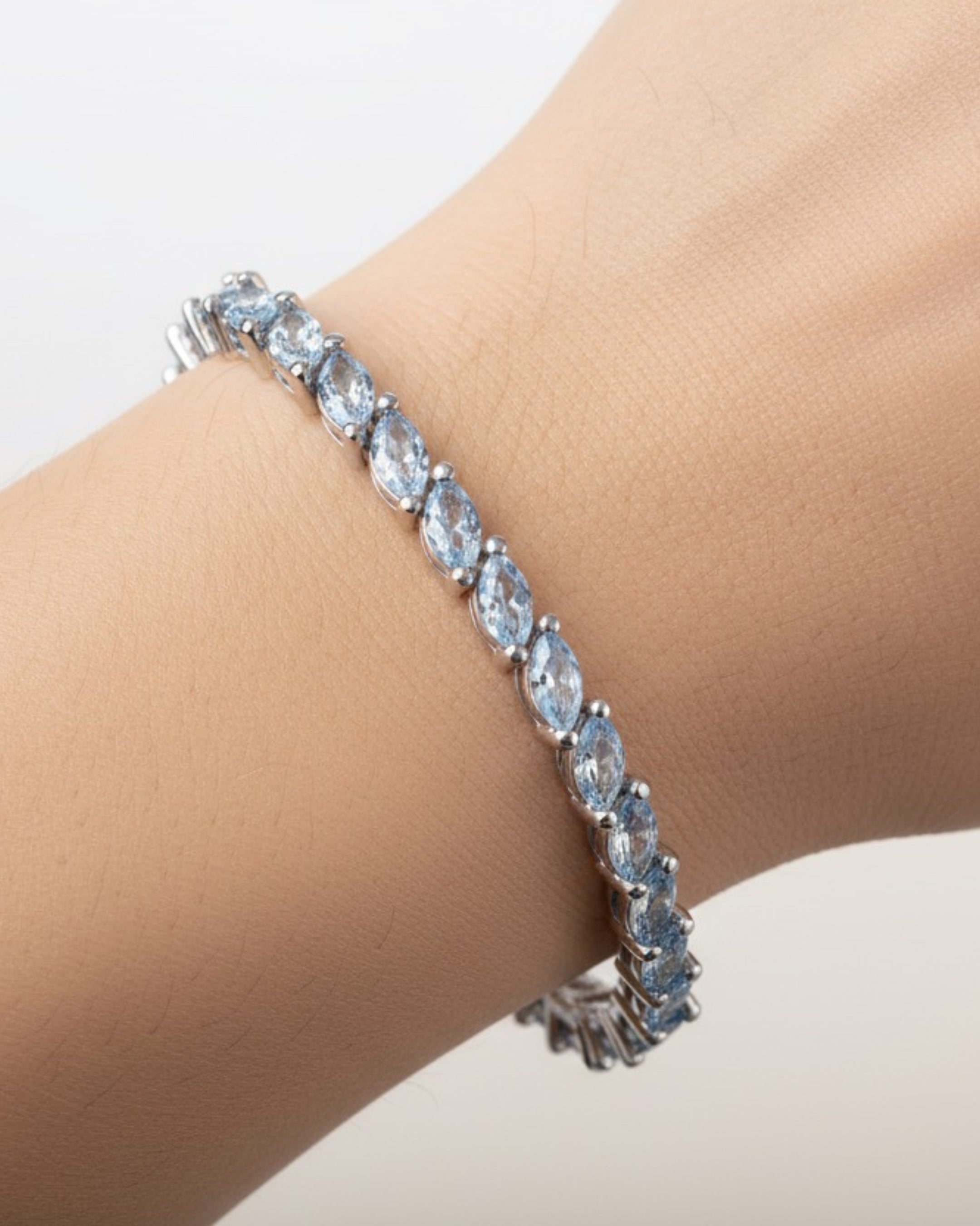 Pulsera elegante en rodio con piedras azul aguamarina luminosas.