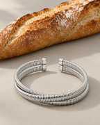 Pulsera tubular LUCE con acabado blanco y forma abierta de estilo contemporáneo.