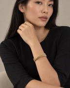 Pulsera VITA de diseño abierto con acabado dorado y líneas limpias de efecto sofisticado.