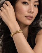Pulsera VITA dorada con textura de líneas verticales que aportan volumen y luminosidad.