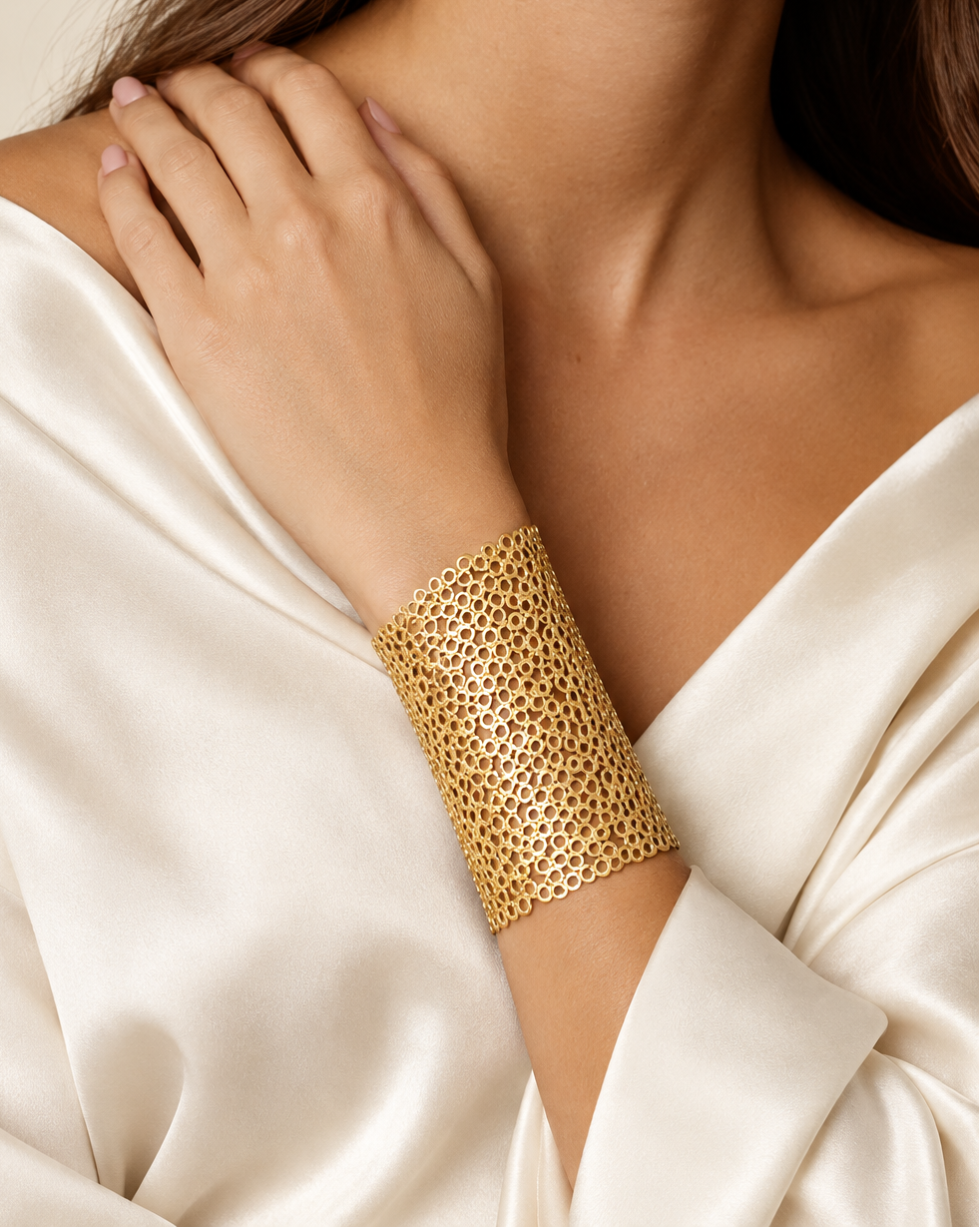 Pulsera ZARB con diseño calado dorado y trama de círculos entrelazados.